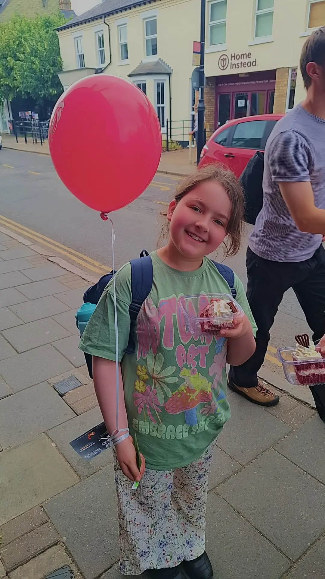 Guest with celebration cake outside The Grill Peri Peri