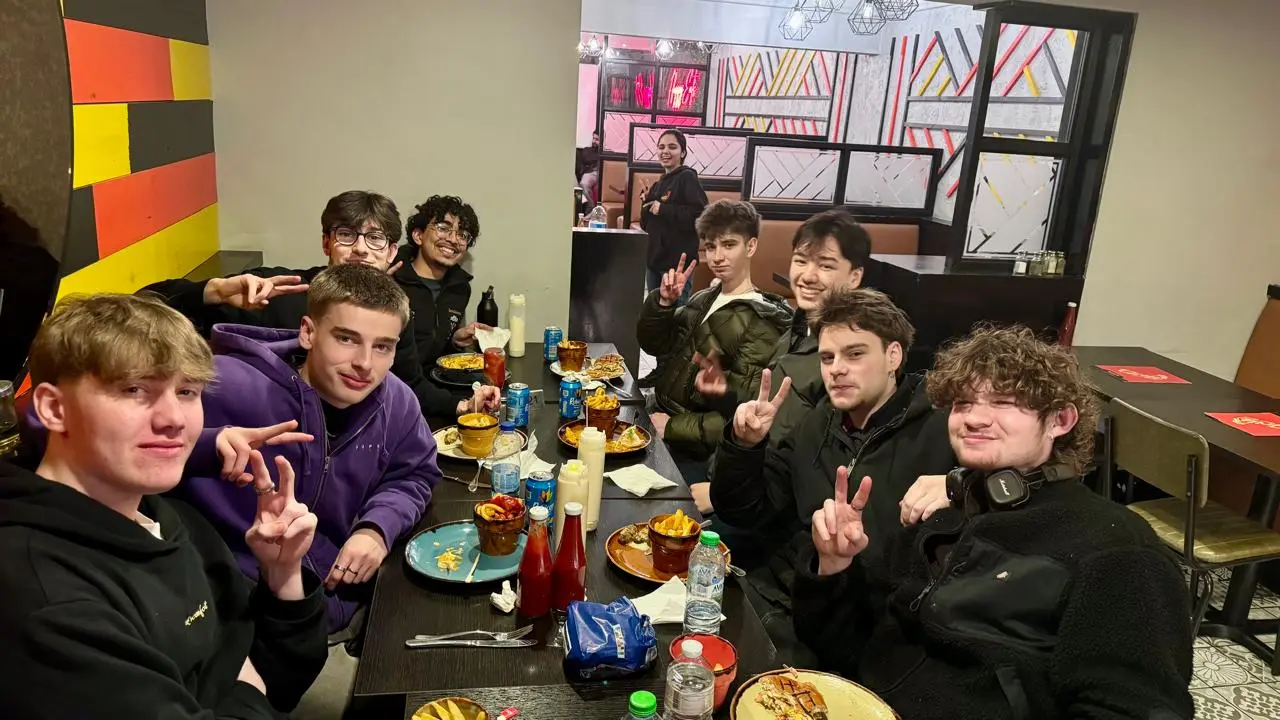 Large group of students sharing a table of grills, wings and sides at The Grill Peri Peri